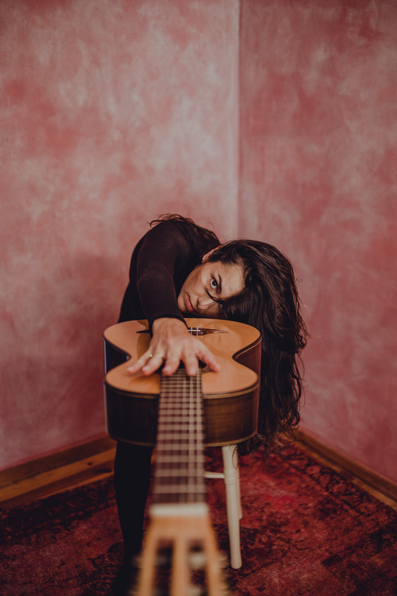 Carolina Zingler debruçada sobre o violão
